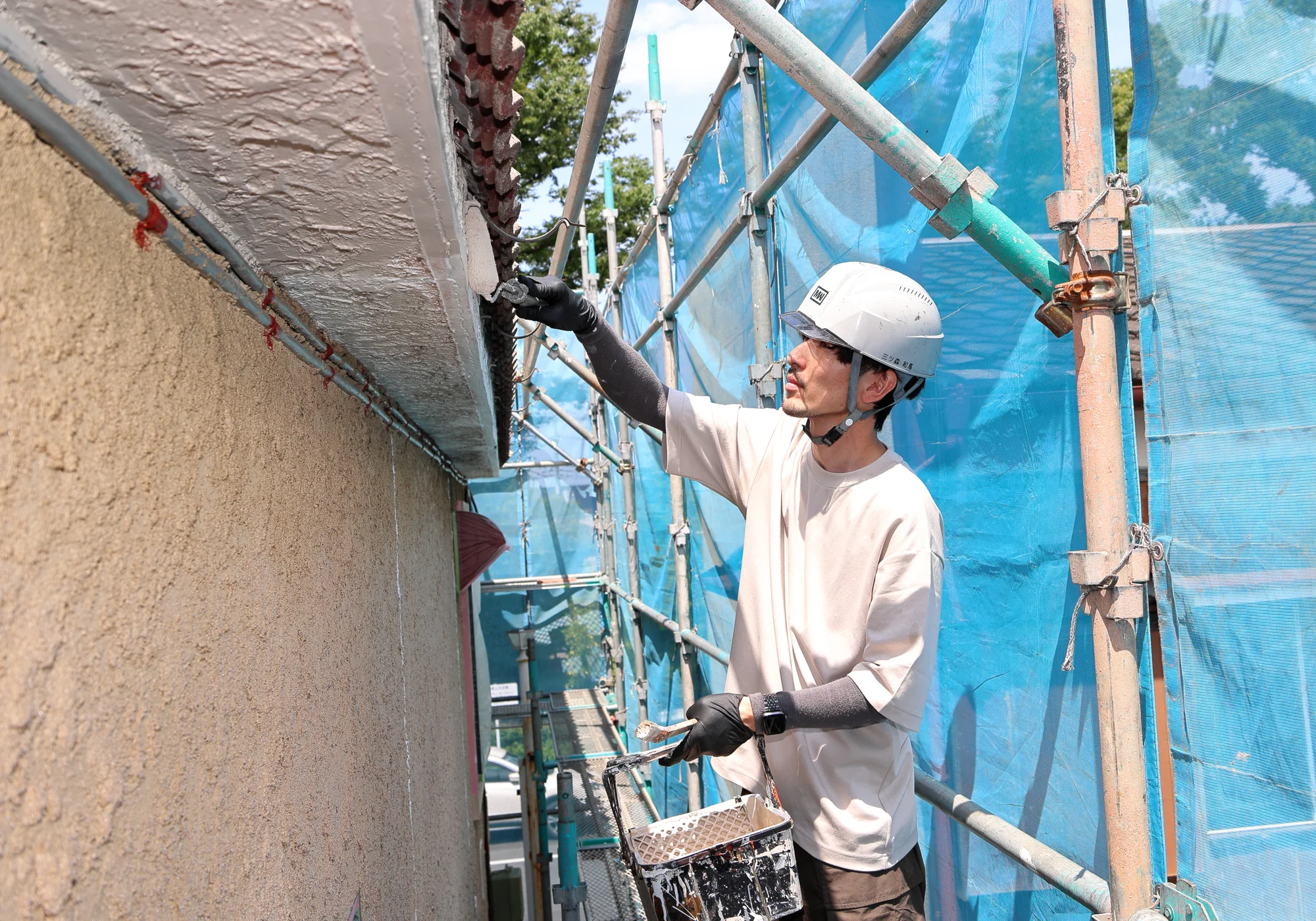 外壁を丁寧に塗装する三ツ和塗装の職人